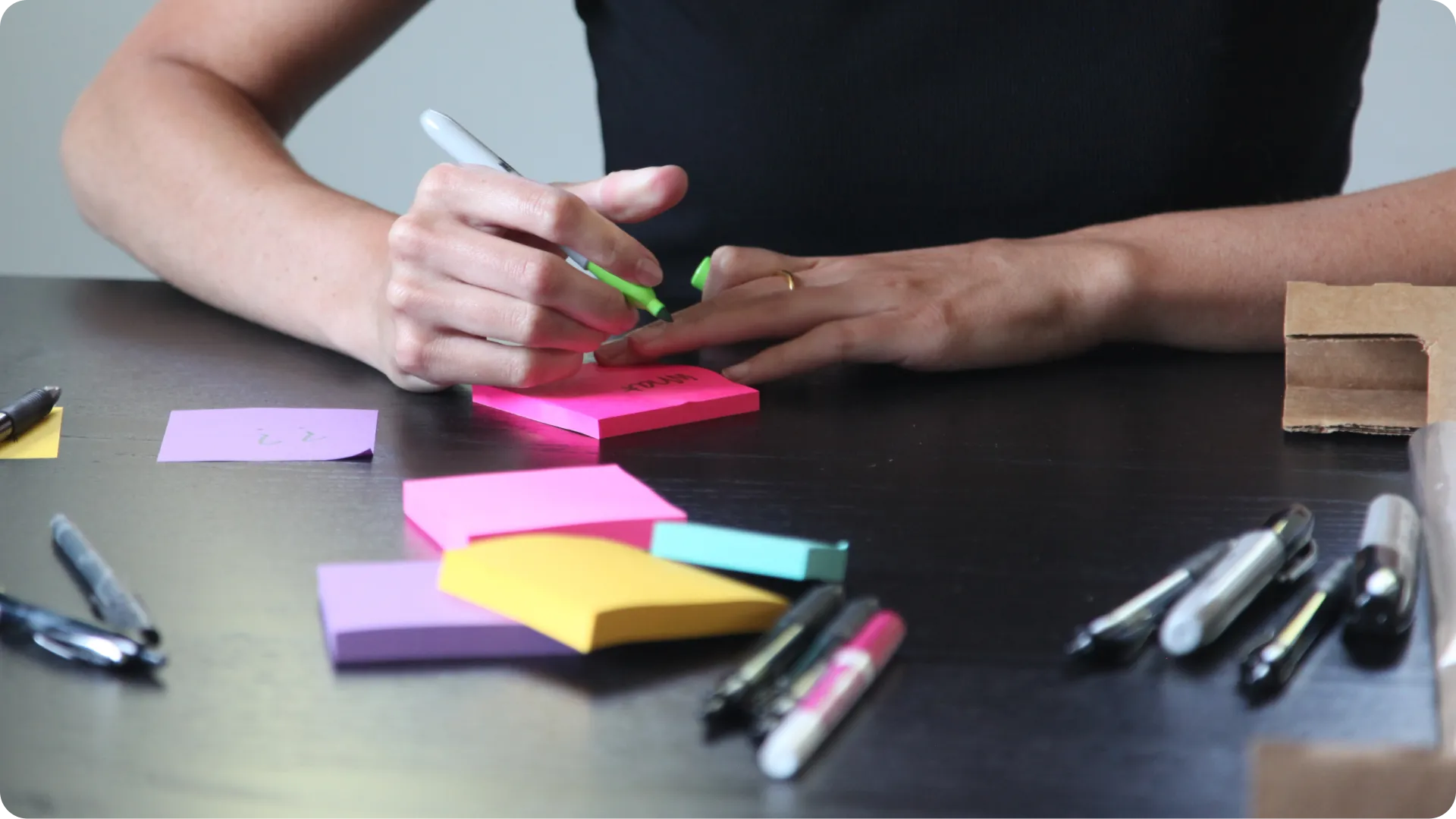 Woman writing on sticky notes.