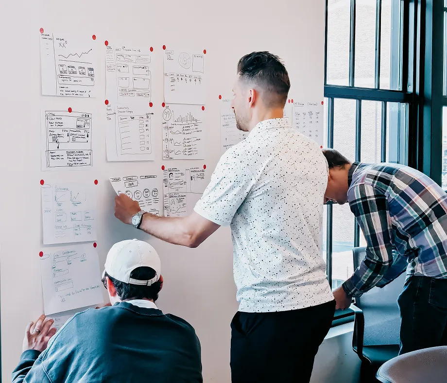 Group of people collaborating with charts and graphs on a wall