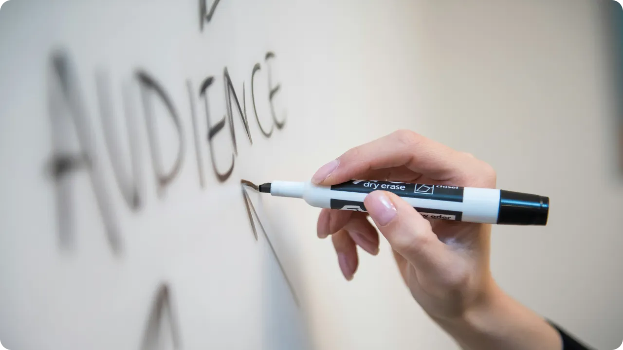 Person writing on a whiteboard.