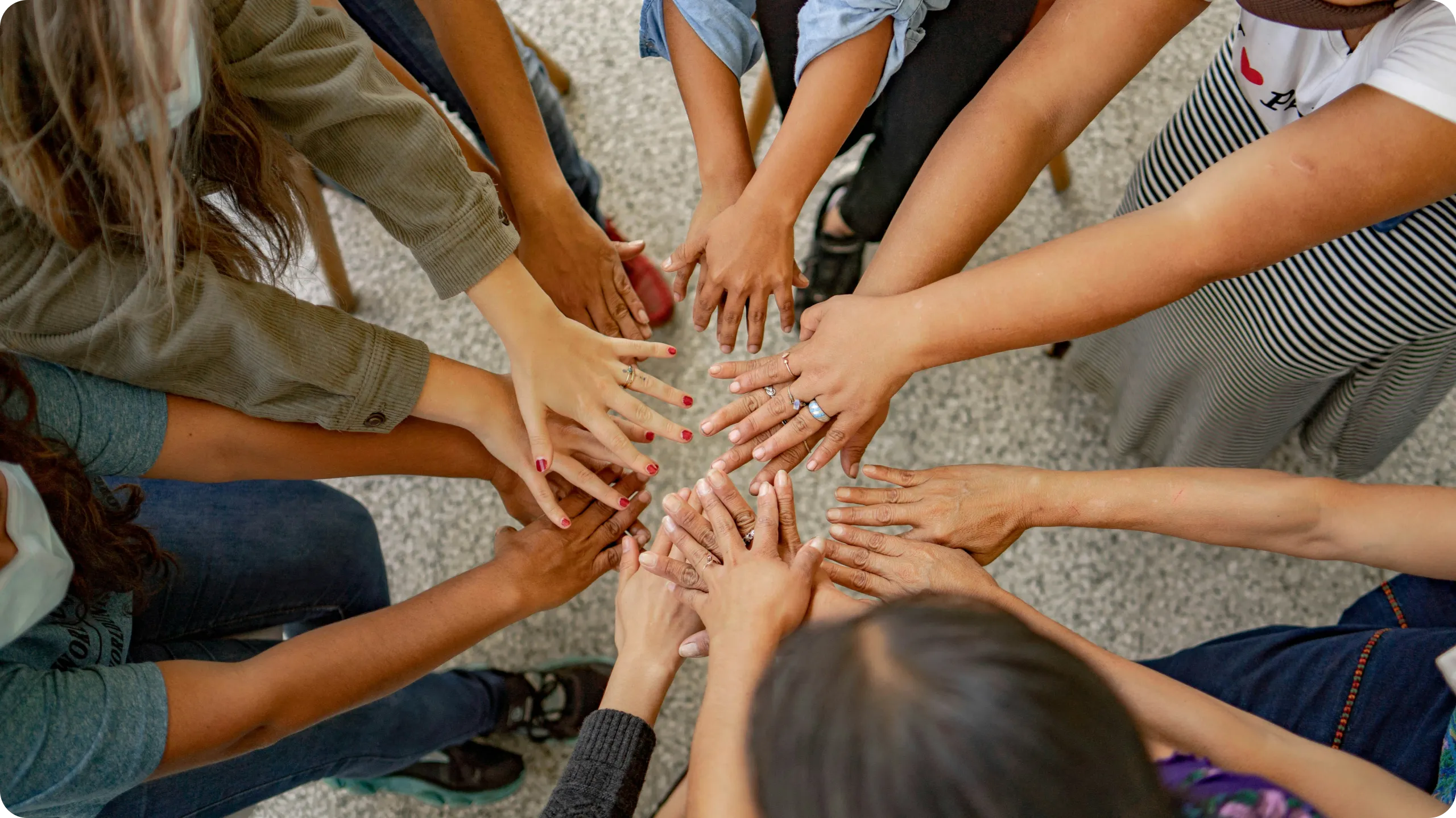 People in a circle putting their hands together.